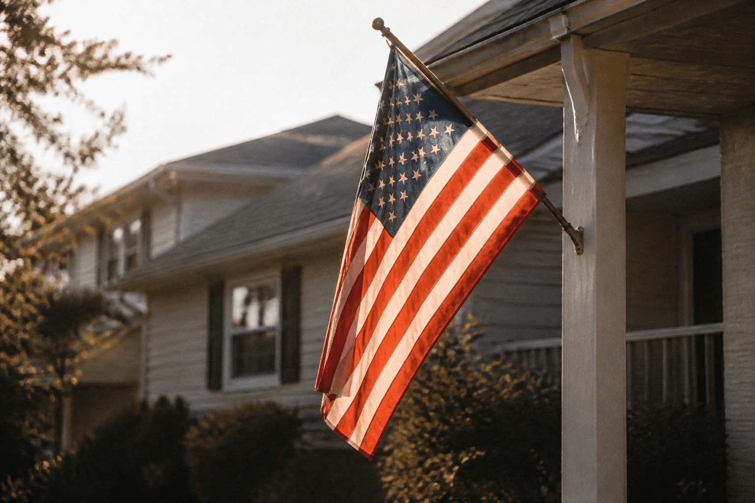 An American flag on a front porch at golden hour